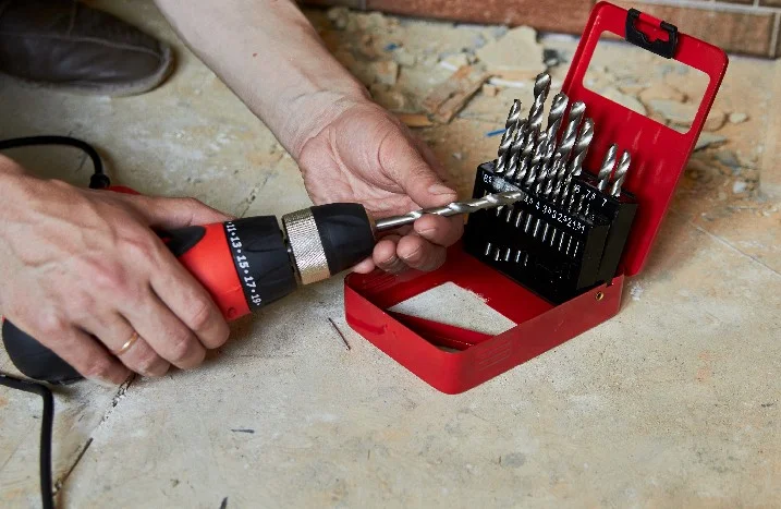 Person hält Bohrer und Bohrerset